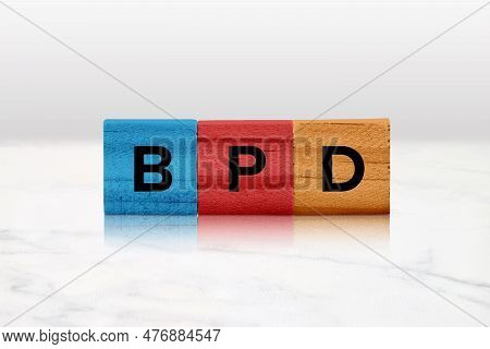 Closeup Of Colored Wooden Tiles Spelling Out Bpd.