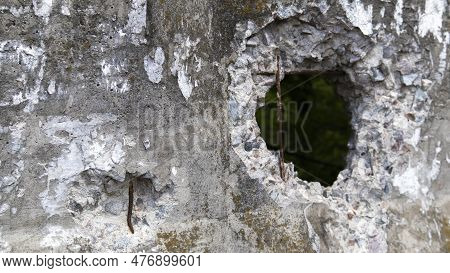 Photo Of A Broken Cement Wall Or Fence. Stone Grunge Odd Wall With A Hole. Damaged Grungy Crack And