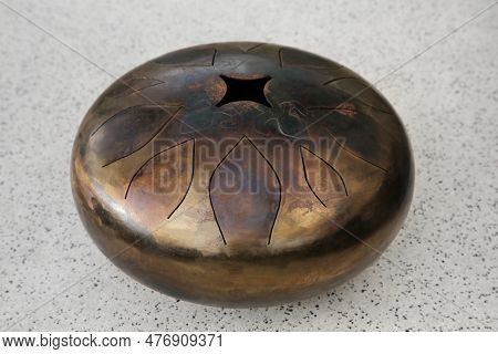 Steel Tongue Drum On Grey Table. Percussion Musical Instrument