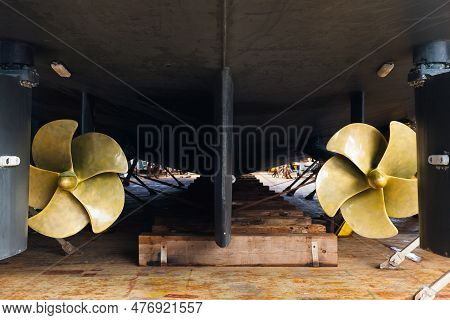 Aft With Two Propellers Of The Luxury Motor Yacht Is Dry Docked On Wooden Blocks And Supported By St