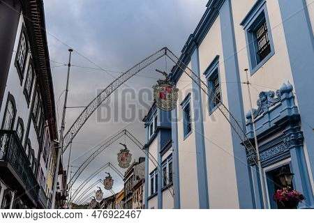 Angra Do Heroismo, Portugal - July 1, 2022: Street Adorned With Steel Pointed Arches And Hanging Coa