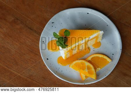 Top View Orange Cake, With Orange Jams Decorated By A Two Piece Of Half Cycle Orange Slides And Gree