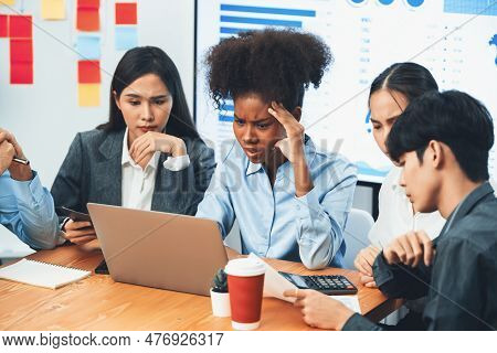 Diverse Businesspeople Analyzing Financial Dashboard Data On Laptop In Serious Meeting, Confused And