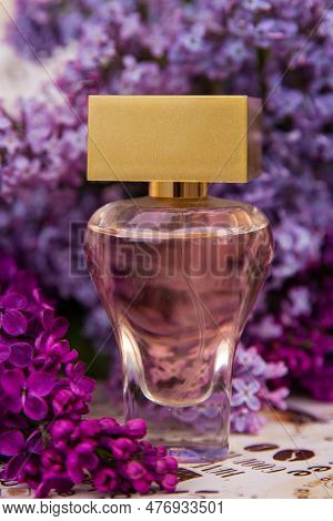 A Bottle Of Perfume Among The Flowers