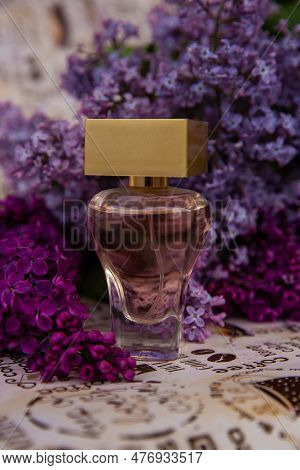 Perfume Among Lilac Flowers, A Bottle Of Perfume Among The Flowers