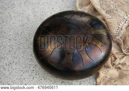 Steel Tongue Drum On Grey Table. Percussion Musical Instrument