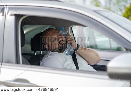 Exhausted Fat Overheat Man With Close Eyes Inside Car With Bottle Of Water On Neck Suffering From Hi