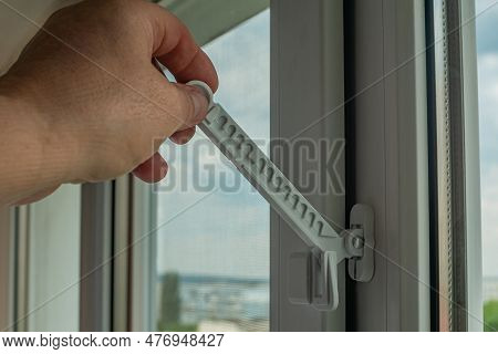 Master Installed Fixing Limiter For Opening A Plastic Window And Checks Its Operation. Close-up Of A