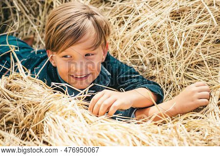 Portrait Of A Cheerful Boy Lying In A Hay. Autumn Dream. Kid Dreams On Autumn Nature. Childhood Drea