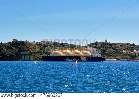 Lng Or Liquified Natural Gas Tanker Moored By Industrial Pier And Green Hill On Sunny Day. Alternati