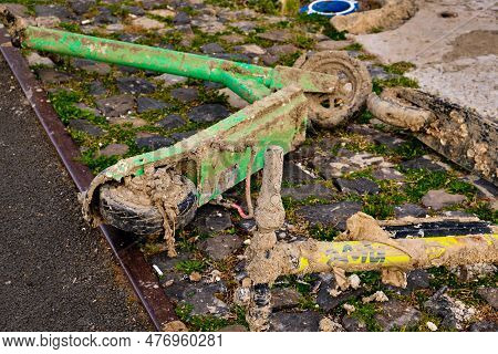 Kick-sharing Rental Electric Scooters Retrieved From Water, Covered In Mud And Garbage, Lie By Water