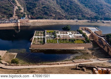 High Angle Zoom-in Shot Of A Unique Garden With Walls In The Middle Of A Pond With Water And Traffic