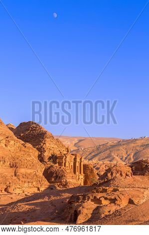 Ad Deir, Monastery, In The Ancient Nabbatean City Of Petra In Jordan At Sunset, Moon In Blue Sky