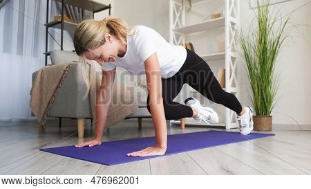 Home Sport. Indoor Workout. Powerful Hardy Woman Fitness Training Plank Running Exercising Beautiful