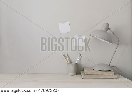 Wooden Desk With Lamp, Books And Cup Holder For Pencils. Note Pad Mockups Taped On Wall. Neutral Sty