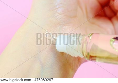 Woman Applying Natural Rollerball Oil Perfume On Her Wrist Close Up