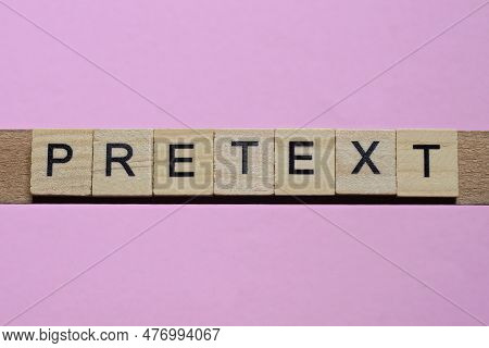 Word Pretext From Small Gray Wooden Letters Lies On A Pink Background