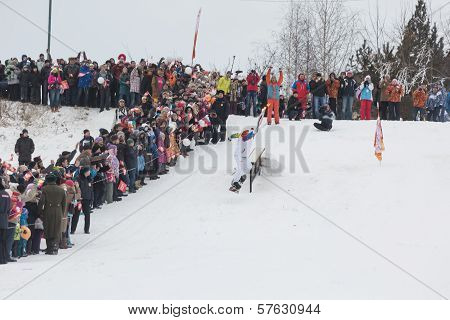 Novosibirsk, Russia - December 7: descent young man on snowboarding with the Olympic torch.