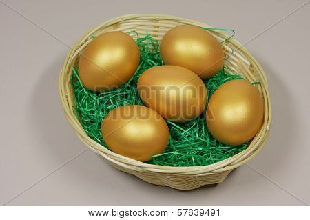 Five Golden Eggs In Basket On Green Grass