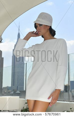 Model wearing couture white dress and posing on the rooftop