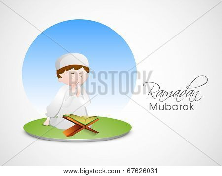 Little Muslim boy reading religious holy Islamic book Quran Shareef on nature background for holy month of Muslim community Ramadan Mubarak. 	