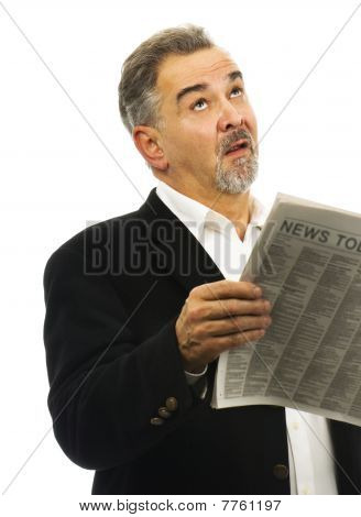 Hombre mira hacia el cielo después de leer el periódico con mirada de desesperación