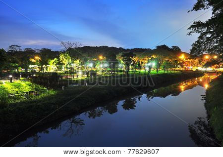 A river with lighted garden in the background