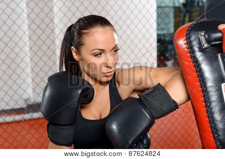 Female fighter trains in a fighting cage
