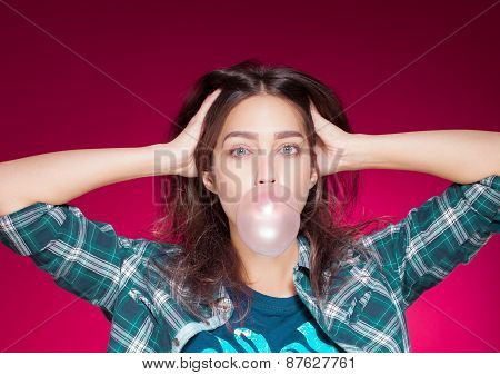 young beautiful girl posing grimacing with chewing gum