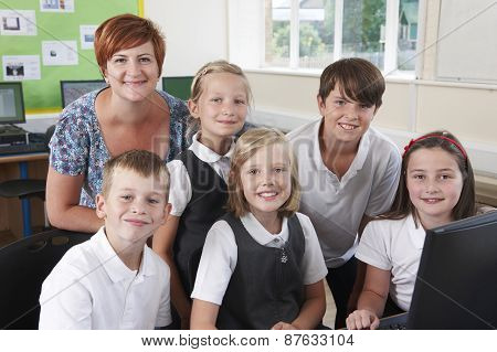 Group Of Elementary Pupils In Computer Class With Teacher