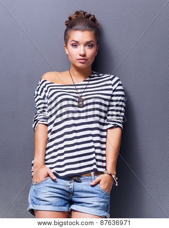 A young woman standing, isolated on graybackground