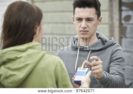 Girl Offering Teenage Boy Cigarette Outdoors