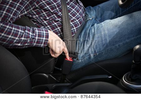 Young Man Driver Pressing Safety Belt Button In Car