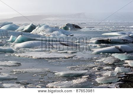 Glacier ice lagoon in Jokullsarlon, Iceland. The glacier breaks up into ice blocks in the lagoon before flowing out to sea as icebergs.