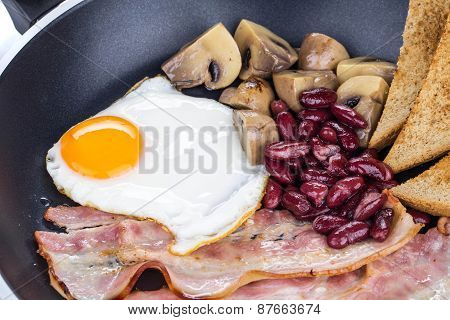 Fried egg with bacon in a frying pan.