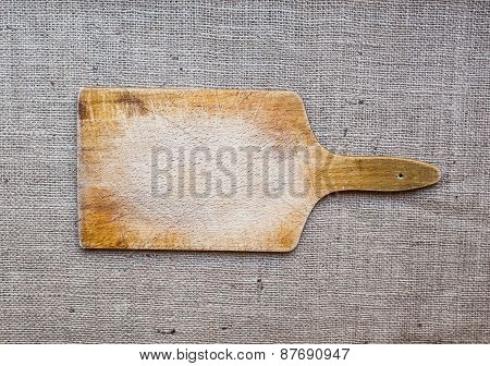 Rustic Wooden Cutting Board Over A Sackcloth Surface