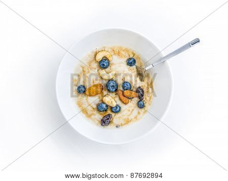 Oat Porridge With Fresh Blueberry, Nuts And Honey In A White Ceramic Bowl On White