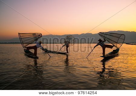 Three fishermen catches fish for food in sunrise in Inle Lake, Myanmar