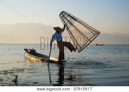 Three fishermen catches fish for food in sunrise in Inle Lake, Myanmar
