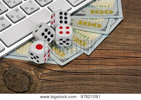 Computer Keyboard, Gaming Dices And Dollar Cash On Wood Background