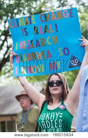 ATLANTA, GA - APRIL 22:  A young woman holds up a funny sign about climate change as she takes part in the Atlanta March for Science near Candler Park in Atlanta GA on Earth Day on April 22 2017.
