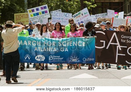 ATLANTA, GA - APRIL 22:  People carry the Atlanta March for Science banner as thousands line up behind to begin the march at Candler Park on Earth Day in Atlanta GA on April 22 2017.