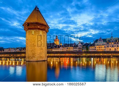 Night view towards Chapel Bridge (Kapellbruecke) together with the octagonal tall tower (Wasserturm) it is one of the Lucerne's most famous tourists attraction