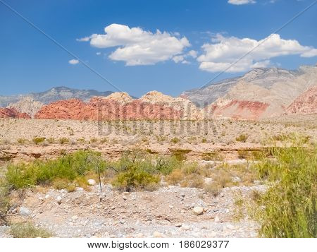 Striped hills in distance under slear blue sky surrounding Red Rock Desert