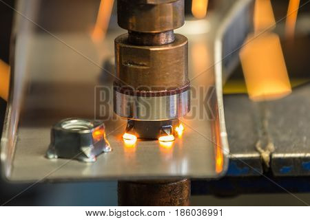 Spot machine is welding nut to automotive part
