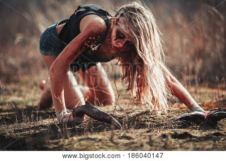 Mutant humpback girl in wounds and ulcers with claws instead of fingers. She crawls on ground.