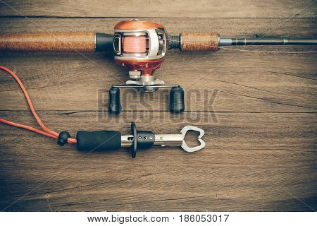Fishing Tackle - Baitcasting Reel, Gripper On  Wooden Background