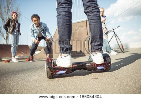 Stylish Hipster Boy Riding Gyroboard With Friends Near By, Teenagers Having Fun Concept