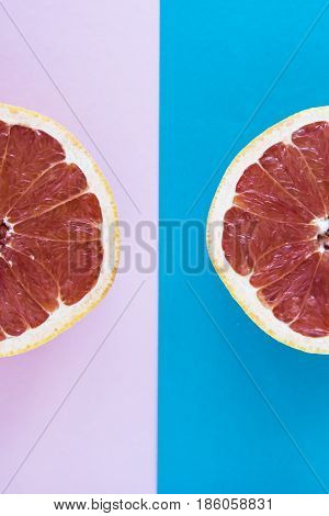 Cut in half a grapefruit on a pink and blue background