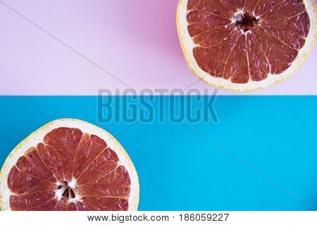 Cut in half a grapefruit on a pink and blue background